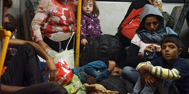 Menschen sitzen auf dem Boden eines Busses Menschen sitzen auf dem Boden eines Busses