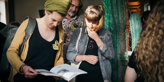 Zwei Frauen sehen sich ein Magazin an Zwei Frauen sehen sich ein Magazin an