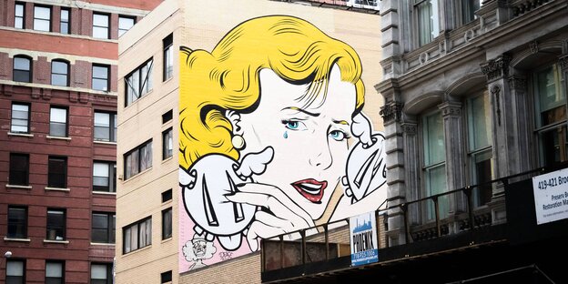 Das Graffiti einer Frau ziert die Fassade eines Hauses Das Graffiti einer Frau ziert die Fassade eines Hauses