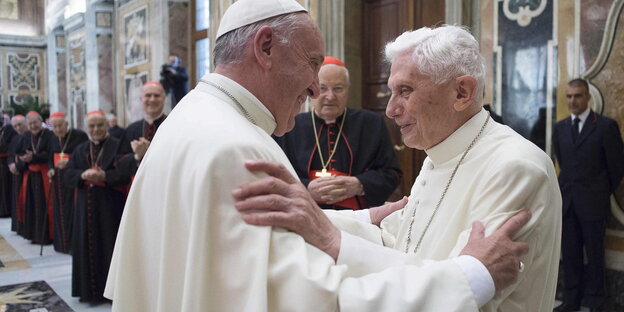Der neue und der alte Papst umarmen sich. Der neue und der alte Papst umarmen sich.
