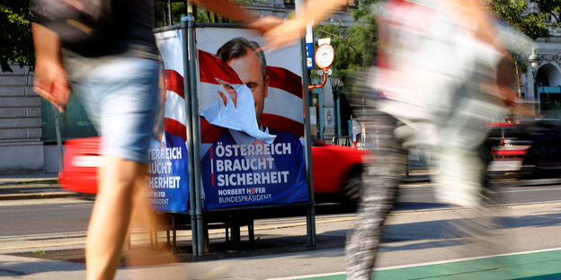 Menschen laufen vor einem Wahlplakat Norbert Hofers vorbei Menschen laufen vor einem Wahlplakat Norbert Hofers vorbei