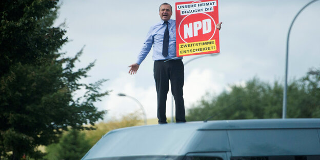 Udo Pastörs steht auf einem weißen Lieferwagen und hält ein NPD-Plakat in der Hand Udo Pastörs steht auf einem weißen Lieferwagen und hält ein NPD-Plakat in der Hand