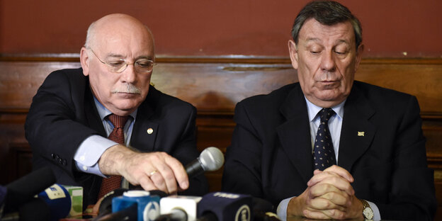 Eladio Loizaga und Roldolfo Nin sitzen hinter Mikrofonen Eladio Loizaga und Roldolfo Nin sitzen hinter Mikrofonen