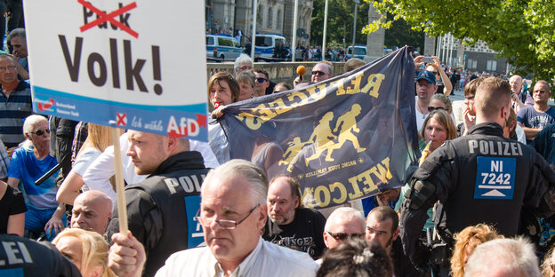 AfD-Anhänger demonstrieren und halten ein Schild hoch auf dem steht: Wir sind das Volk AfD-Anhänger demonstrieren und halten ein Schild hoch auf dem steht: Wir sind das Volk
