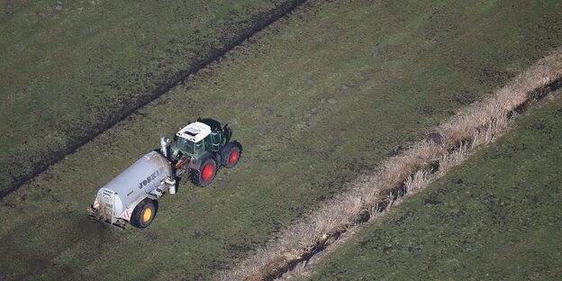 Ein Tracktor verteilt Gülle auf dem Feld Ein Tracktor verteilt Gülle auf dem Feld