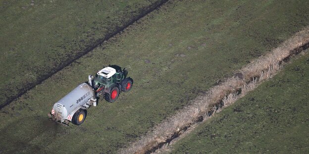 Ein Tracktor verteilt Gülle auf dem Feld