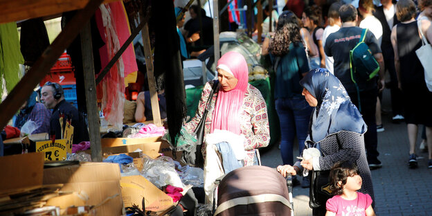Zwei Frauen kaufen auf einem Markt ein