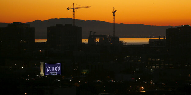 Panoramablick auf San Francisco bei Sonnenaufgang, ein Yahoo-Schild leuchtet in der dunklen Häusermasse Panoramablick auf San Francisco bei Sonnenaufgang, ein Yahoo-Schild leuchtet in der dunklen Häusermasse