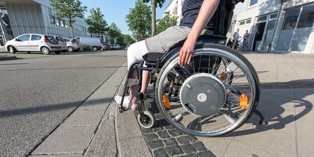 Rollstuhlfahrer an Bordsteinkante Rollstuhlfahrer an Bordsteinkante