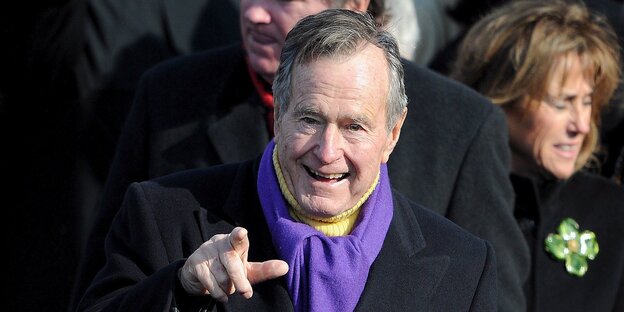 George H. W. Bush mit pastellgelbem Rollkragenpullover und lila Schal George H. W. Bush mit pastellgelbem Rollkragenpullover und lila Schal