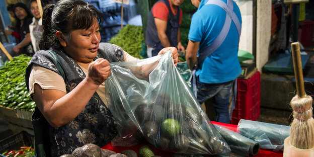 Zum Kauf angebotene Avocados, eine davon aufgeschnitten Zum Kauf angebotene Avocados, eine davon aufgeschnitten