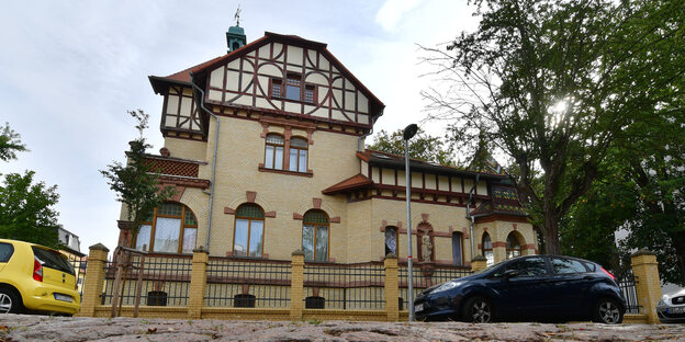 Ein Haus, vor dem Autos parken Ein Haus, vor dem Autos parken