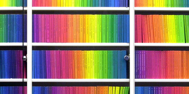 Mehrere Bücherregal überreinander, die voller Bücher sind, welche in Regenbogenfarben angeordnet stehen Mehrere Bücherregal überreinander, die voller Bücher sind, welche in Regenbogenfarben angeordnet stehen
