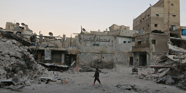 Zertrümmerte Straßen von Aleppo, Menschen gehen zwischen den zerstörten Häusern Zertrümmerte Straßen von Aleppo, Menschen gehen zwischen den zerstörten Häusern