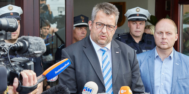 Der Innenminister von Schleswig-Holstein, Stefan Studt, spricht vor einer Tür in Fernsehkameras Der Innenminister von Schleswig-Holstein, Stefan Studt, spricht vor einer Tür in Fernsehkameras