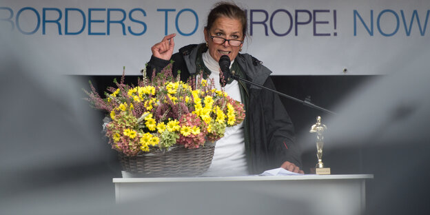 Tatjana Festerling steht an einem Rednerpult und gestikuliert, vor ihr ein Korb mit Blumen Tatjana Festerling steht an einem Rednerpult und gestikuliert, vor ihr ein Korb mit Blumen