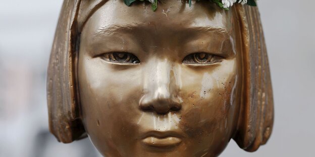 Eine Statue zeigt das emotionslose Gesicht eines koreanischen Mädchens Eine Statue zeigt das emotionslose Gesicht eines koreanischen Mädchens