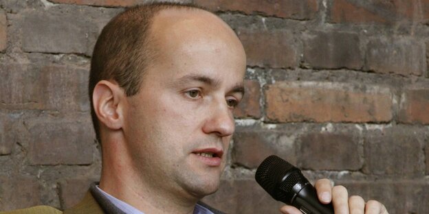 Nicolaus Fest hält sich ein Mikro an den Mund Nicolaus Fest hält sich ein Mikro an den Mund