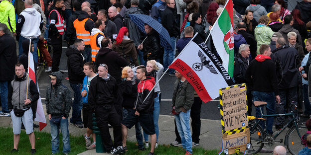 Ansammlung von rechts gerichteten DemonstratInnen der Pegida, einige von ihnen mit Fahnen