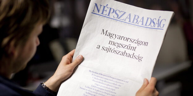 Eine Frau hält eine Ausgabe der Népszabadság in ihrer Hand Eine Frau hält eine Ausgabe der Népszabadság in ihrer Hand