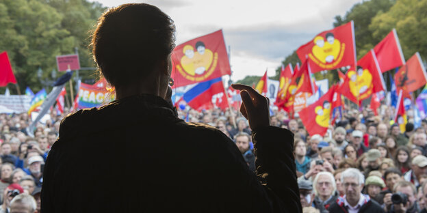 Wagenknechts schwarze Silhoutte bei einer Rede vor DemonstrantInnen