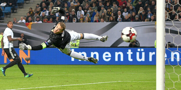Thomas Neuer fliegt waagerecht durch die Luft und lenkt einen Ball vom Tor ab Thomas Neuer fliegt waagerecht durch die Luft und lenkt einen Ball vom Tor ab