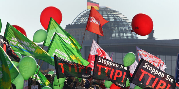 Flaggen von Ceta- und TTIP-Demonstrant*innen wehen vor der Reichstagskuppel Flaggen von Ceta- und TTIP-Demonstrant*innen wehen vor der Reichstagskuppel