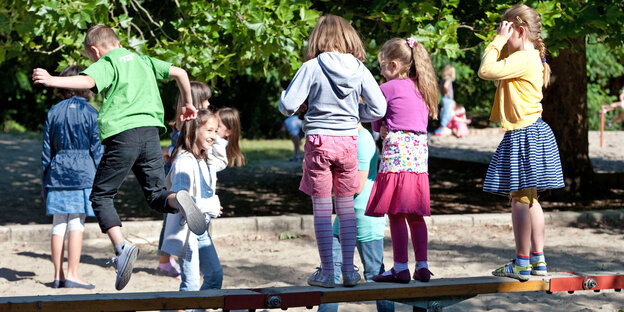 Kinder auf einem Kinderspielplatz Kinder auf einem Kinderspielplatz