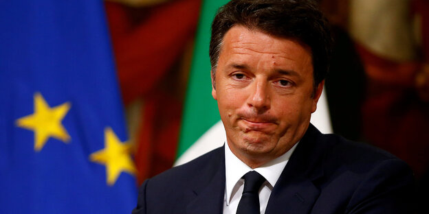 Matteo Renzi mit zusammengepressten Lippen vor einer EU- und einer Italienflagge Matteo Renzi mit zusammengepressten Lippen vor einer EU- und einer Italienflagge