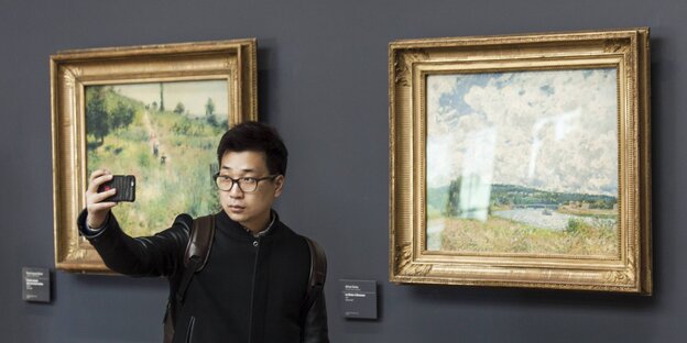 Ein Mann macht ein Selfie in einem Museum Ein Mann macht ein Selfie in einem Museum