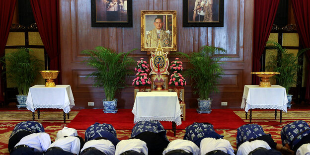 Menschen knien vor einem Bild von Thailands König Bhumibol Menschen knien vor einem Bild von Thailands König Bhumibol