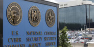 Schild der National Security Agency (NSA), dahinter ein Parkplatz und ein Gebäude