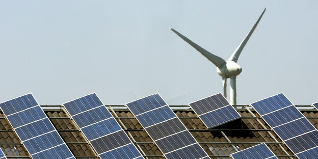 Ein Windrad hinter einer Solaranlage Ein Windrad hinter einer Solaranlage