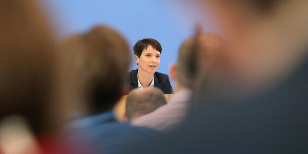 Frauke Petry hinter verschwommenen Silhouetten Frauke Petry hinter verschwommenen Silhouetten