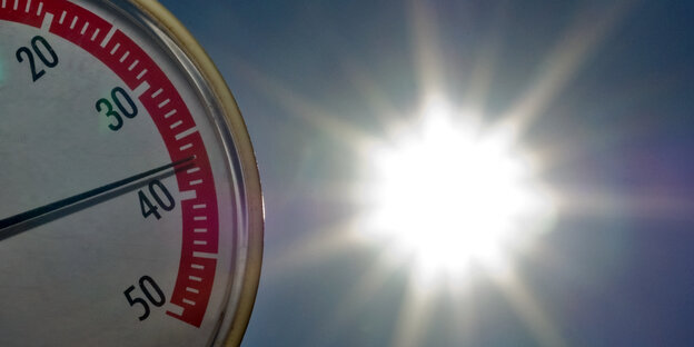 Eine Temperaturanzeige und die Sonne im Hintergrund Eine Temperaturanzeige und die Sonne im Hintergrund