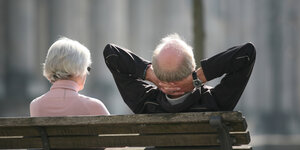 zwei alte Menschen sitzen auf einer Parkbank