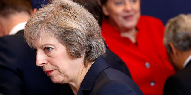 Theresa May guckt zur Seite. Hinter ihr steht Angela Merkel Theresa May guckt zur Seite. Hinter ihr steht Angela Merkel