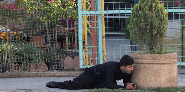 Ein Kurde liegt in Kirkuk hinter einem Blumentopf und versteckt sich vor dem „Islamischen Staat“ Ein Kurde liegt in Kirkuk hinter einem Blumentopf und versteckt sich vor dem „Islamischen Staat“