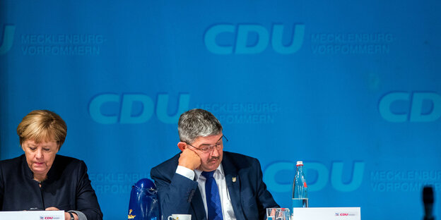 Angela Merkel und Sascha Ott von einerm blauen Hintergrund auf dem „CDU Mecklemburg-Vorpommern“ steht Angela Merkel und Sascha Ott von einerm blauen Hintergrund auf dem „CDU Mecklemburg-Vorpommern“ steht