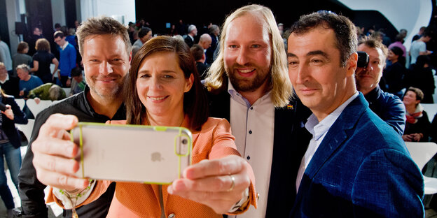 drei Männer und eine Frau, sie macht ein Selfie von allen drei Männer und eine Frau, sie macht ein Selfie von allen