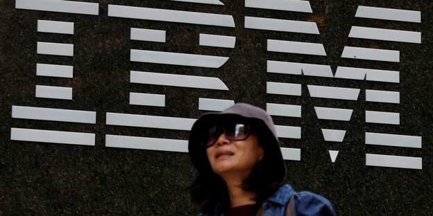 Eine Frau läuft am IBM-Logo vorbei Eine Frau läuft am IBM-Logo vorbei