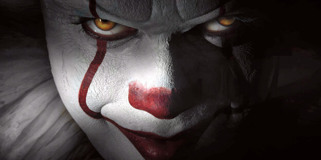 Ein Clown mit weißem Gesicht, roter Nase und rotem Mund blickt grimmig Ein Clown mit weißem Gesicht, roter Nase und rotem Mund blickt grimmig