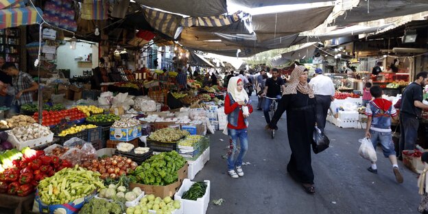 Menschen auf einem Markt beim Einkaufen Menschen auf einem Markt beim Einkaufen