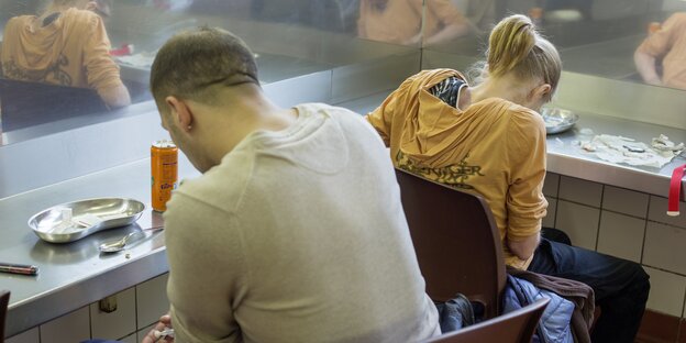 Ein Mann und eine Frau sitzen in einer Drückerstube Ein Mann und eine Frau sitzen in einer Drückerstube