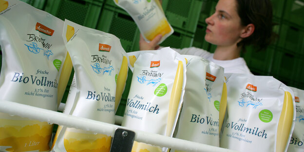 Eine Mitarbeiterin überwacht die Abfüllung von Demeter-Milch Eine Mitarbeiterin überwacht die Abfüllung von Demeter-Milch