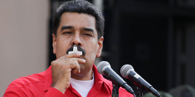Nicolas Maduro, im roten Hemd, küsst ein Kreuz Nicolas Maduro, im roten Hemd, küsst ein Kreuz