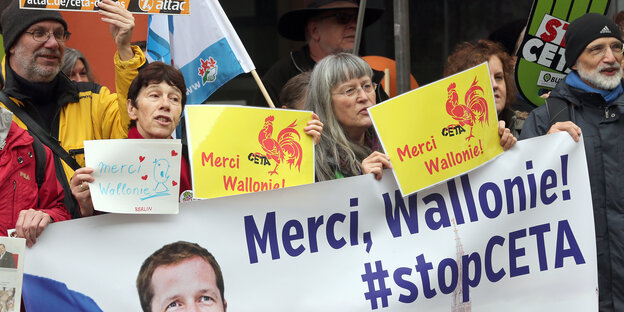 Menschen bei einer Demonstration gegen CETA die den Walloniern auf Plakaten danken Menschen bei einer Demonstration gegen CETA die den Walloniern auf Plakaten danken