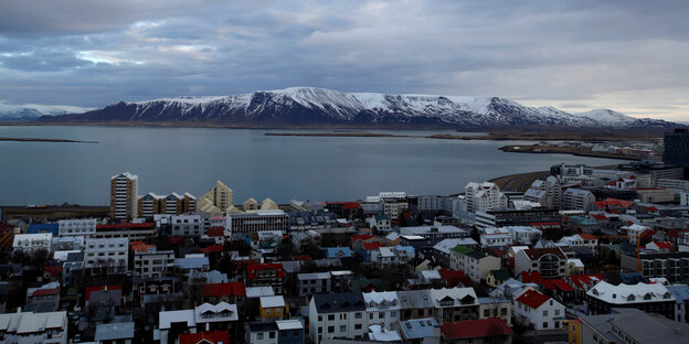 Häuser von Reykjavik, dahinter eine Bucht und darüber bewölkter Himmel Häuser von Reykjavik, dahinter eine Bucht und darüber bewölkter Himmel