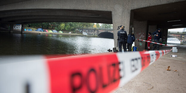Polizeiabsperrung unter einer Brücke an einem Fluss Polizeiabsperrung unter einer Brücke an einem Fluss