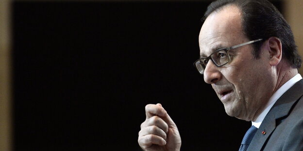 Ein Mann im Profil rechts im Bild gestikuliert, im Hintergrund eine schwarze Fläche Ein Mann im Profil rechts im Bild gestikuliert, im Hintergrund eine schwarze Fläche